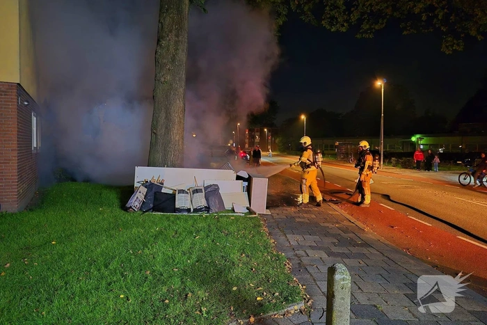 Brandweer blust brandende hoop grofvuil