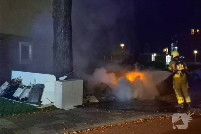 Brandweer blust brandende hoop grofvuil