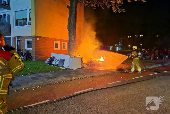 Brandweer blust brandende hoop grofvuil