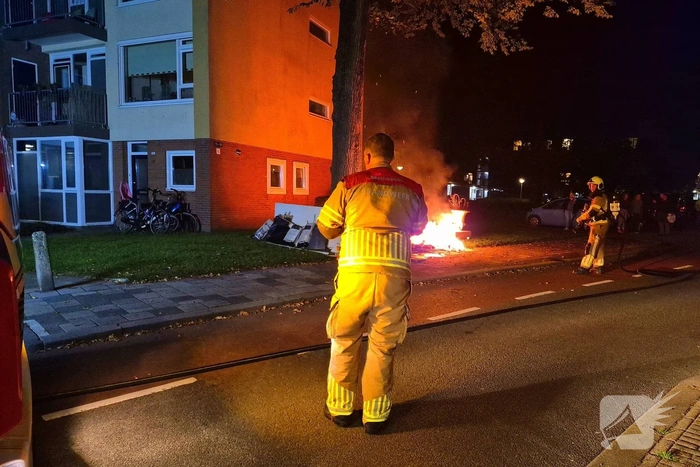 Brandweer blust brandende hoop grofvuil