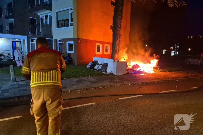 Brandweer blust brandende hoop grofvuil