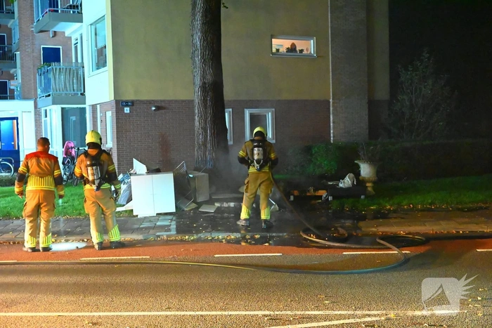 Brandweer blust brandende hoop grofvuil