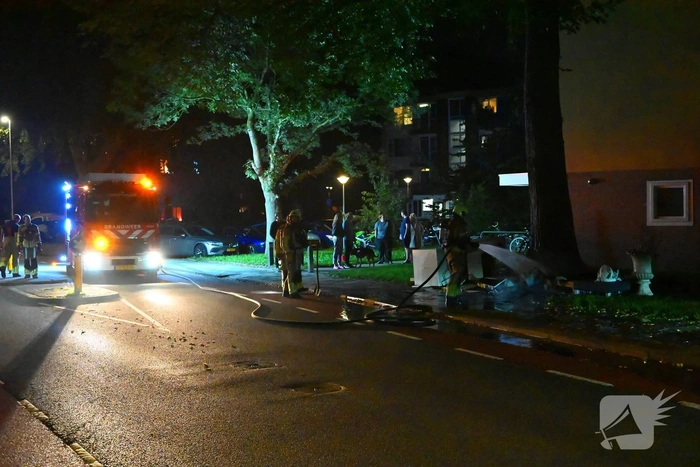 Brandweer blust brandende hoop grofvuil