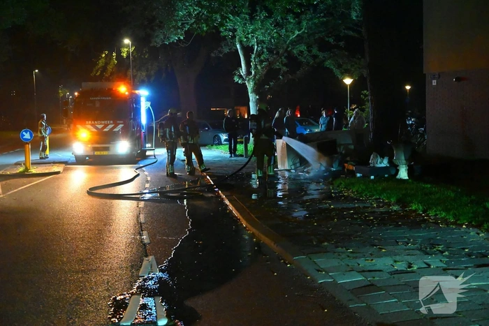 Brandweer blust brandende hoop grofvuil