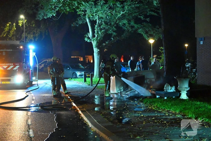 Brandweer blust brandende hoop grofvuil