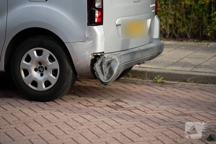 Auto op zijkant na botsing tegen geparkeerde auto
