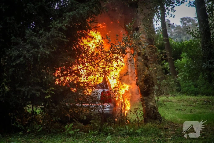 Personenauto volledig in brand tussen oude barakken