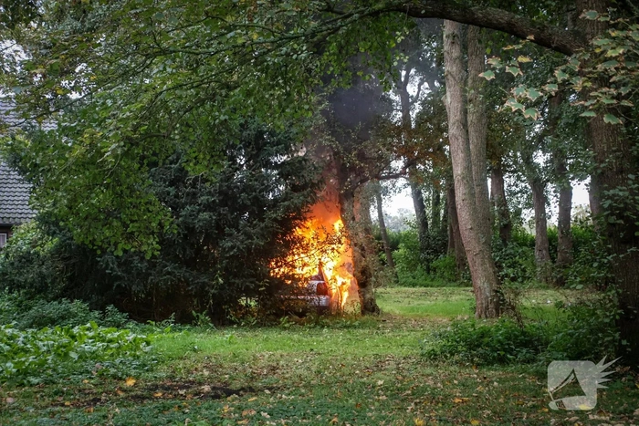 Personenauto volledig in brand tussen oude barakken