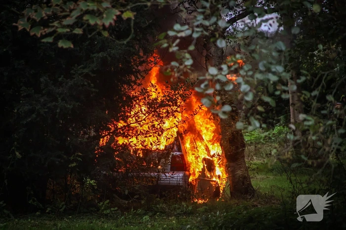 Personenauto volledig in brand tussen oude barakken