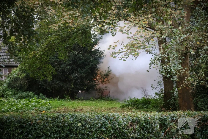 Personenauto volledig in brand tussen oude barakken