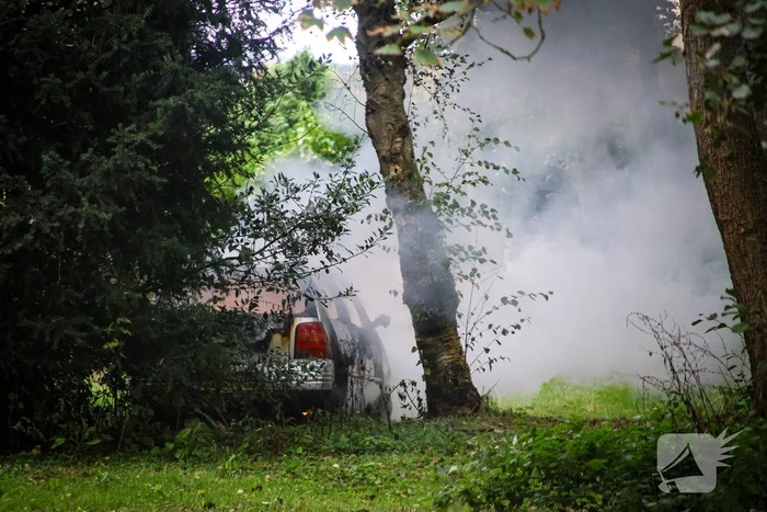 Personenauto volledig in brand tussen oude barakken