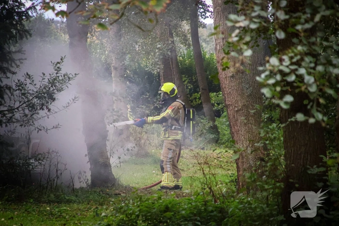 Personenauto volledig in brand tussen oude barakken