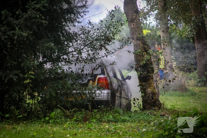 Personenauto volledig in brand tussen oude barakken