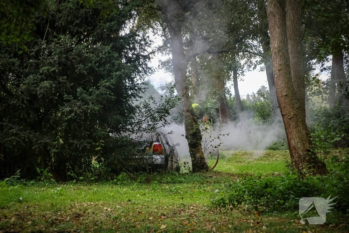 Personenauto volledig in brand tussen oude barakken