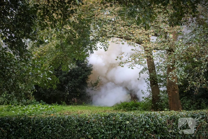 Personenauto volledig in brand tussen oude barakken