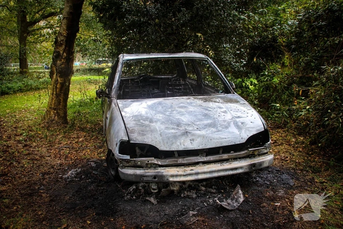 Personenauto volledig in brand tussen oude barakken