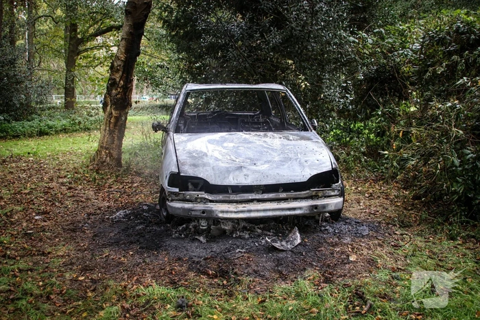 Personenauto volledig in brand tussen oude barakken