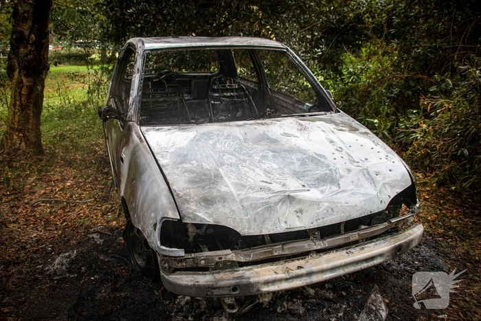 Personenauto volledig in brand tussen oude barakken