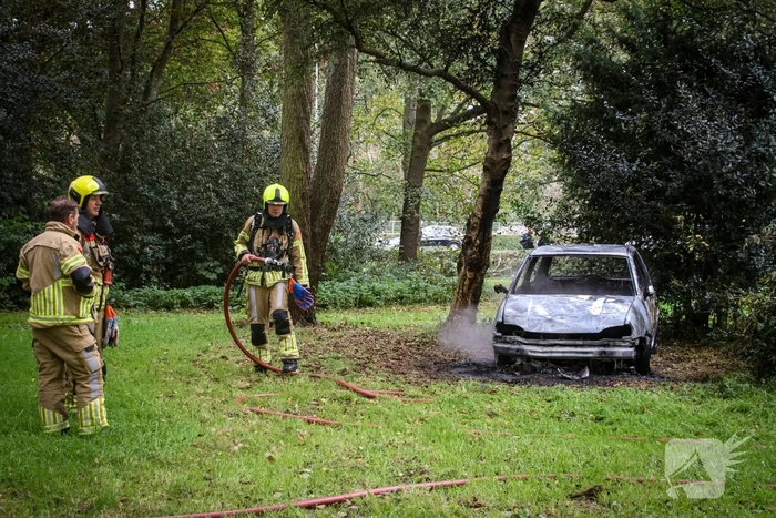Personenauto volledig in brand tussen oude barakken
