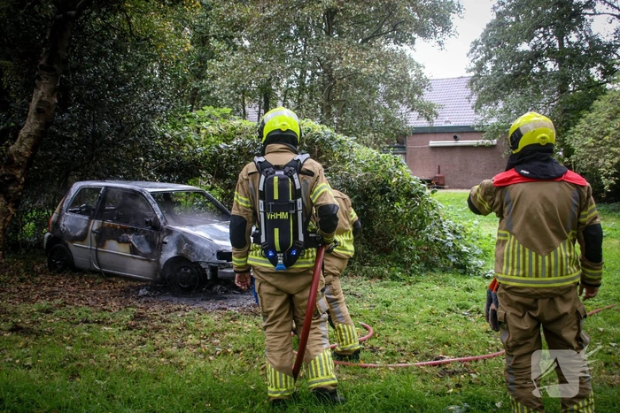 Personenauto volledig in brand tussen oude barakken