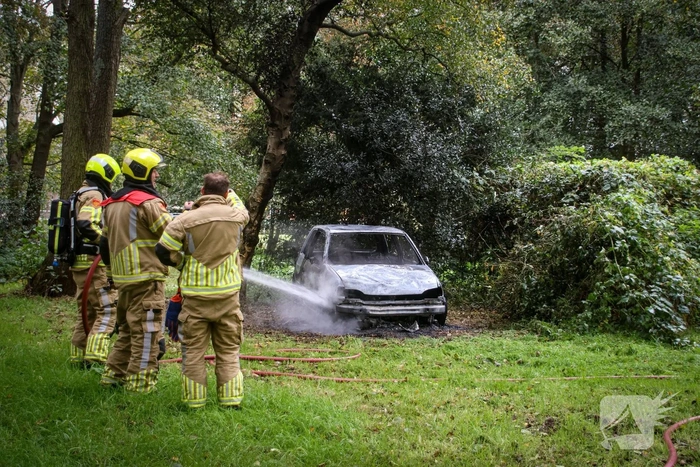 Personenauto volledig in brand tussen oude barakken