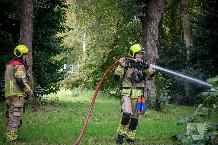 Personenauto volledig in brand tussen oude barakken