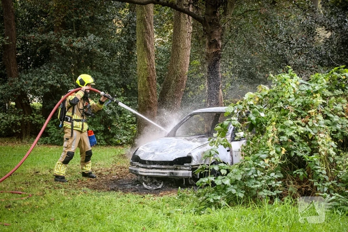 Personenauto volledig in brand tussen oude barakken
