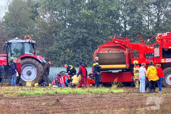 Man bekneld in aardappelrooier