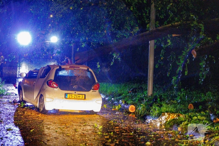 Boom valt op auto door storm