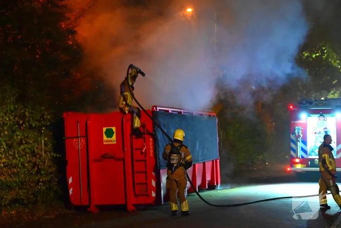 Brand in grote container achter brandweerkazerne