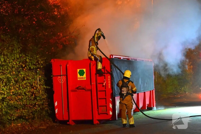 Brand in grote container achter brandweerkazerne