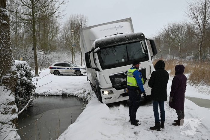 Vrachtwagen komt tot stilstand boven sloot
