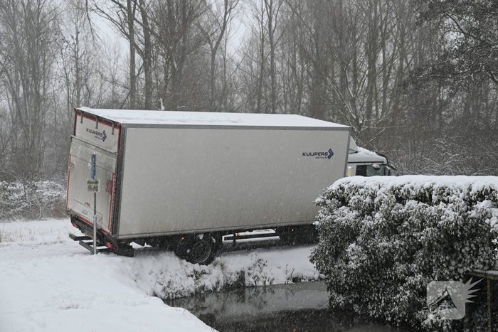 Vrachtwagen komt tot stilstand boven sloot