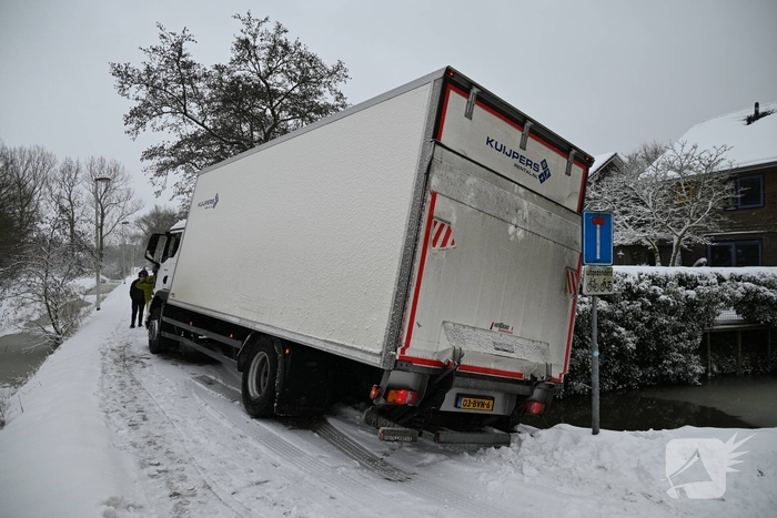 Vrachtwagen komt tot stilstand boven sloot