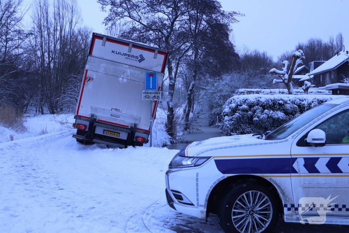 Vrachtwagen komt tot stilstand boven sloot