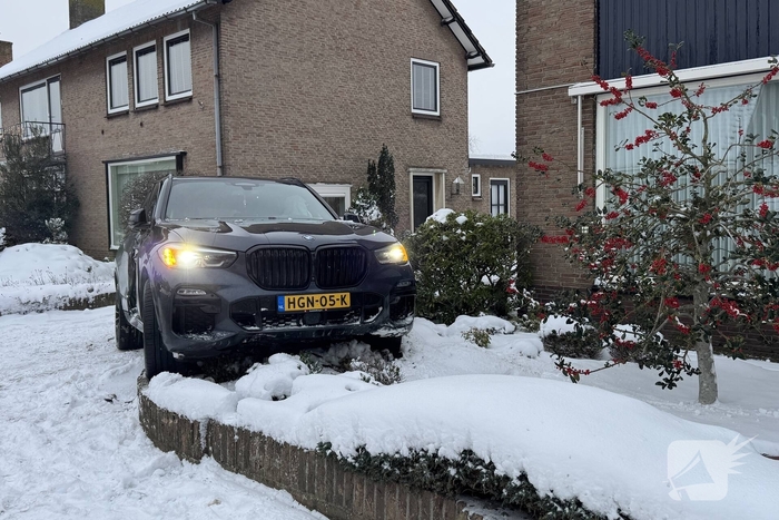 BMW crasht in voortuin na botsing