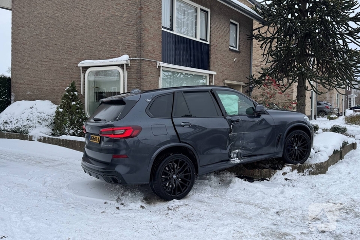 BMW crasht in voortuin na botsing