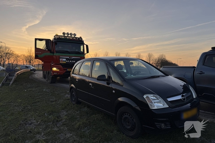 Vrachtwagen en auto botsen op rotonde