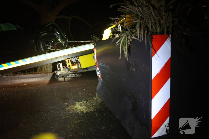 Auto botst tegen verkeersplaten