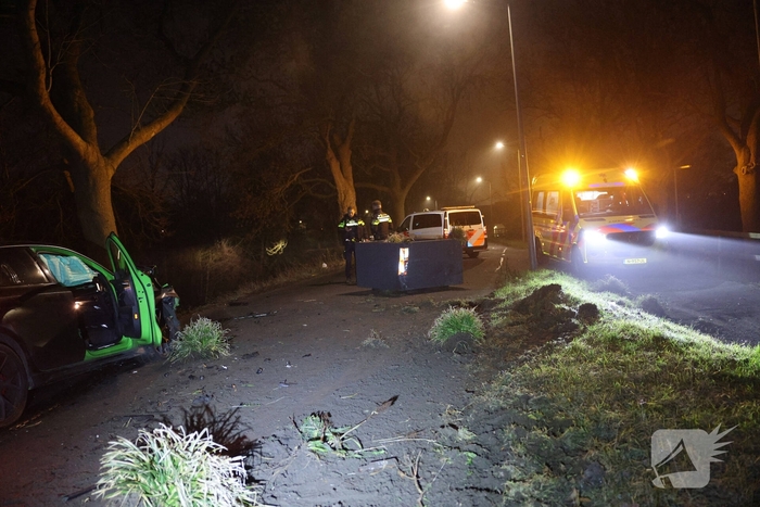 Auto botst tegen verkeersplaten