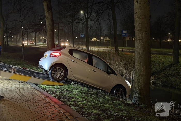 Personenauto belandt deels in water