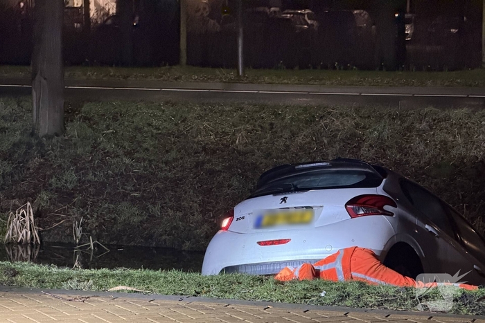 Personenauto belandt deels in water