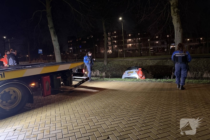 Personenauto belandt deels in water