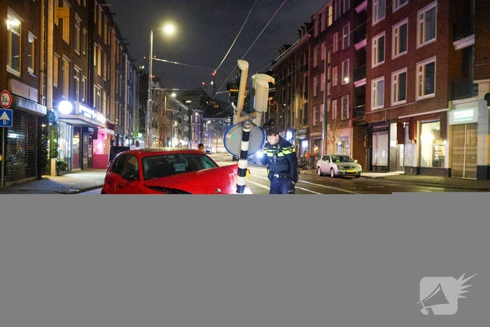 Auto rijdt stoplicht omver op druk kruispunt