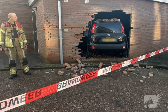 Vrouw rijdt dwars door muur van schuur