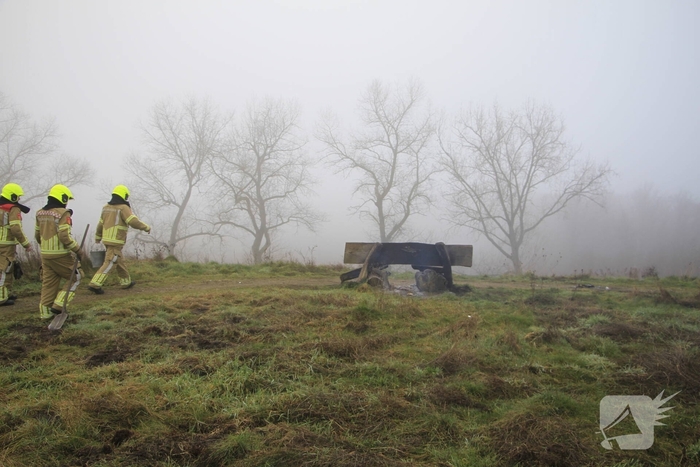 Buitenbrand onder monumentale bank na barbecue