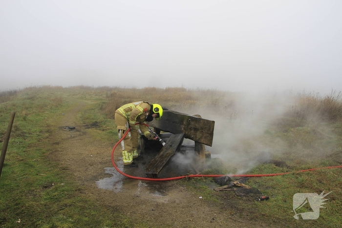 Buitenbrand onder monumentale bank na barbecue