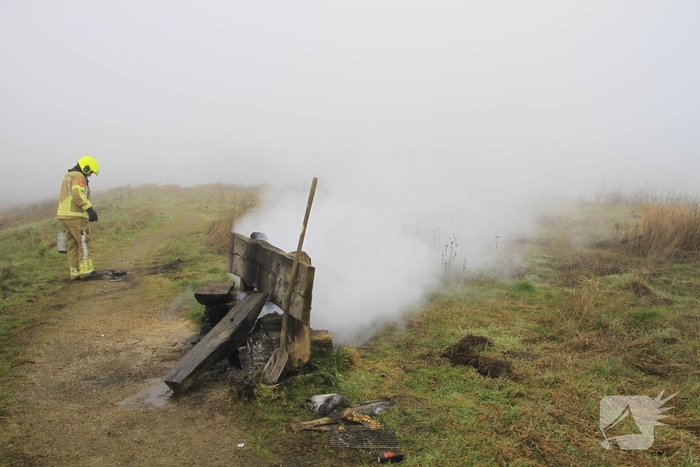 Buitenbrand onder monumentale bank na barbecue