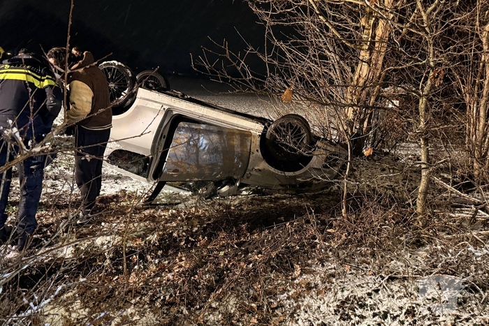 Auto raakt van de weg en belandt op de kop