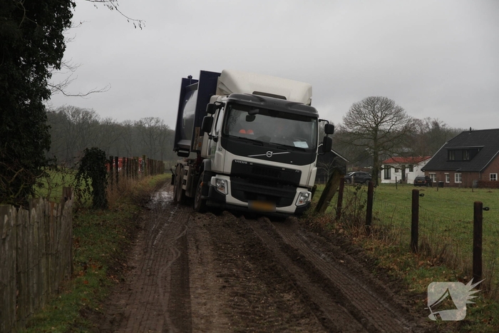 Vuilniswagen raakt paal en blijft vastzitten